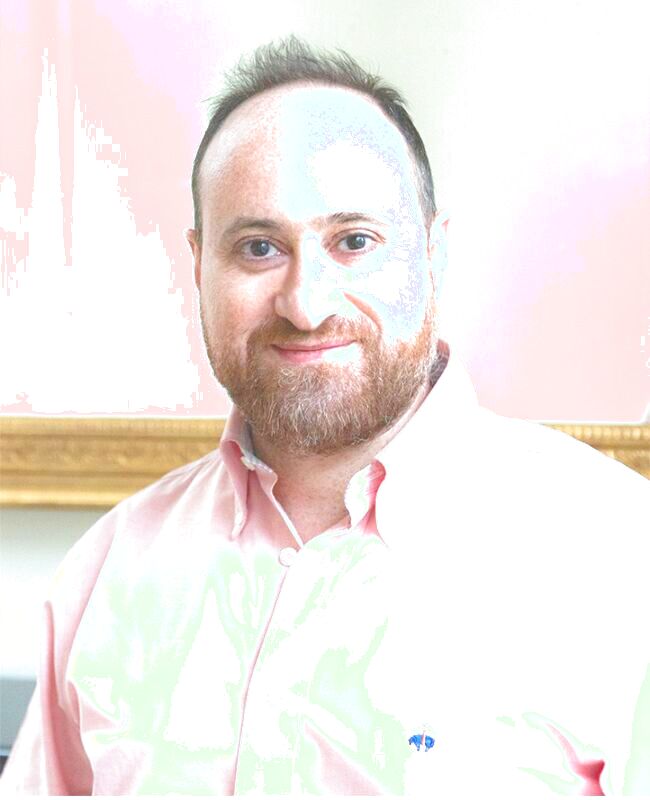Zu sehen ist ein Portrait des Komponisten Zaid Jabri. Er trägt ein rosa Hemd und blickt freundlich in die Kamera.