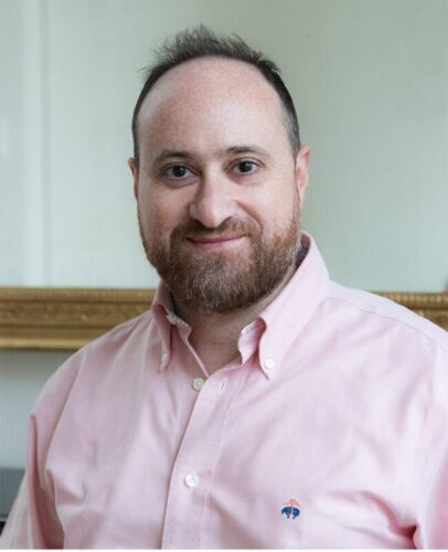 Zu sehen ist ein Portrait des Komponisten Zaid Jabri. Er trägt ein rosa Hemd und blickt freundlich in die Kamera.