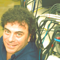 Zu sehen ist ein Portrait des Kompnisten Luca Francesconi. Neben seinem Kopf sind zahlreiche Kabel zu sehen.