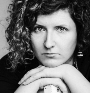 Schwarz-weißes Porträt einer Frau (Olga Bubich), den Kopf auf die verschränkten Arme gestützt.