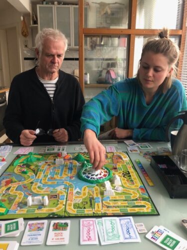 Der Komponist Uwe Rasch und eine weitere Person spielen das Brettspiel "Das Spiel Des Lebens".