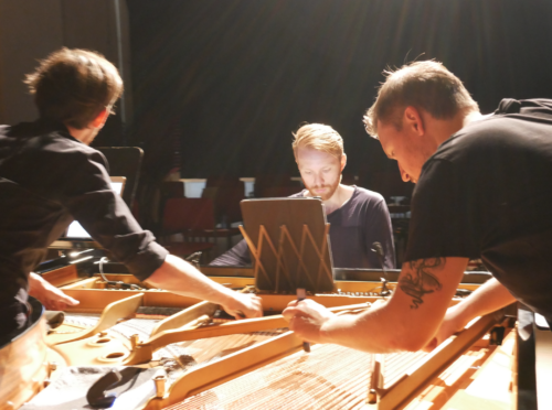 Zu sehen ist das Trio Pony Says, zu dritt bespielen sie einen Flügel: Felix Nagl spielt an den Tasten, Lucas Gerin und Thilo Ruck bespielen die Saiten im Innenraum.